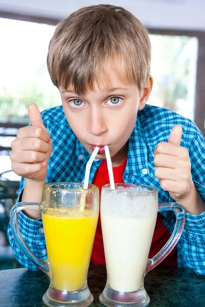 Lindo niño divertido beber cócteles de frutas de dos vasos grandes con pajitas. Concepto de bebida creativa . —  Fotos de Stock