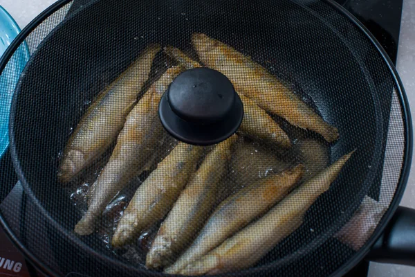 Pequeno peixe saboroso cheiroso frito em um prato quente de churrasco — Fotografia de Stock