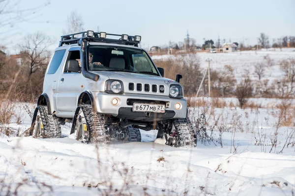 O carro monta em trilhas no inverno — Fotografia de Stock