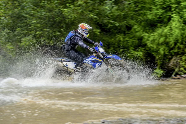 Motocicleta rio Enduro em um lugar raso do spray — Fotografia de Stock