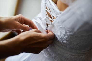 bruid proberen op trouwjurk