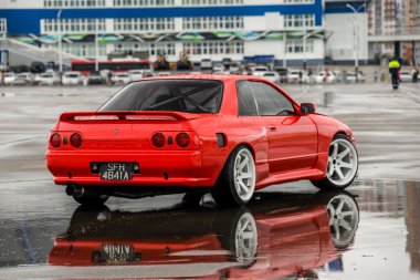 Nissan skyline R 32 kırmızı renk bir ıslak yolda