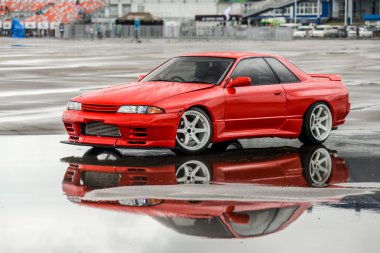 Nissan skyline R 32 kırmızı renk bir ıslak yolda