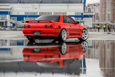 Nissan skyline R 32 kırmızı renk bir ıslak yolda
