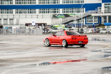 Nissan skyline R 32 kırmızı renk bir ıslak yolda