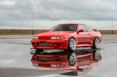 Nissan skyline R 32 kırmızı renk bir ıslak yolda