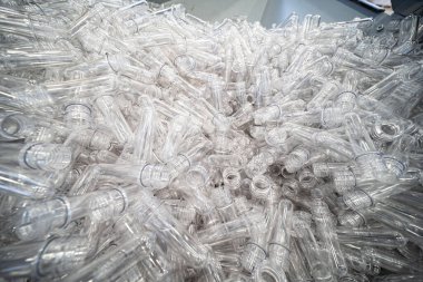 Çeşitli tip plastik şişe ürünü ve enjeksiyon kalıplı preform malzeme. İçme kabı üretim işlemi.