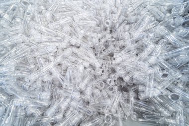 Çeşitli tip plastik şişe ürünü ve enjeksiyon kalıplı preform malzeme. İçme kabı üretim işlemi.