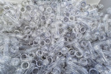 Çeşitli tip plastik şişe ürünü ve enjeksiyon kalıplı preform malzeme. İçme kabı üretim işlemi.