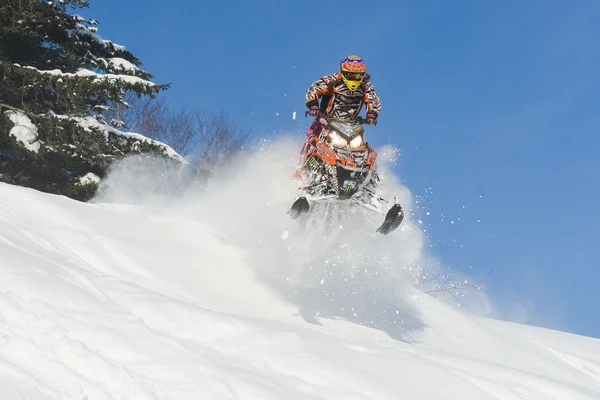 Moto de nieve en el bosque de invierno en las montañas —  Fotos de Stock