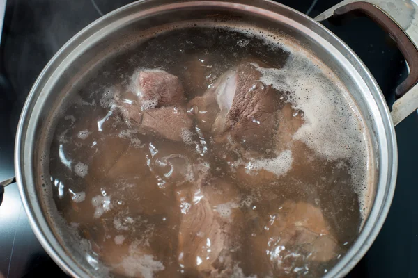 Meat is cooked in boiling water — Stock Photo, Image