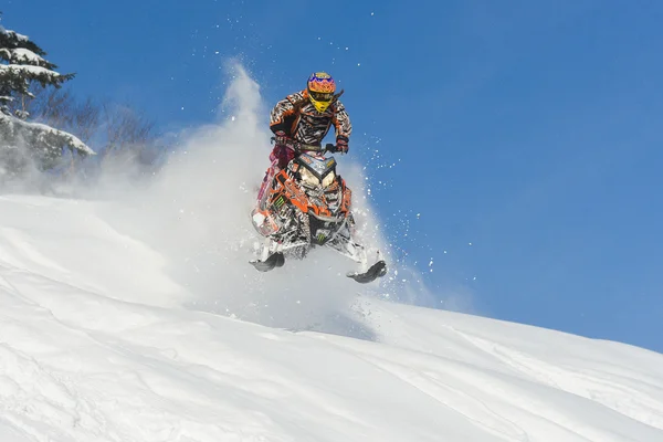 Athlete on a snowmobile moving  in the mountains — Stock Photo, Image