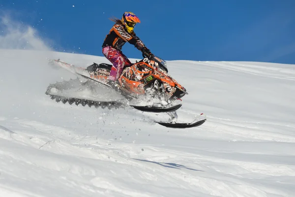 Atleta em um snowmobile que se move nas montanhas — Fotografia de Stock