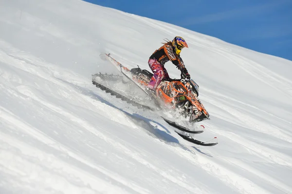 Atleta em um snowmobile que se move nas montanhas — Fotografia de Stock