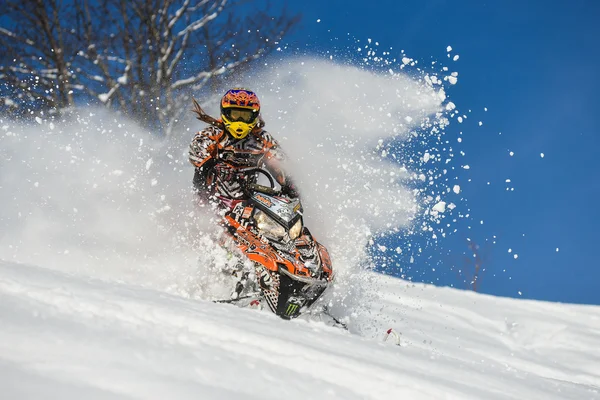 Спортсмен на снегоходе, движущийся в горах — стоковое фото