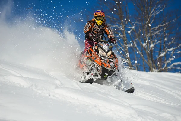Atleta em um snowmobile que se move nas montanhas — Fotografia de Stock