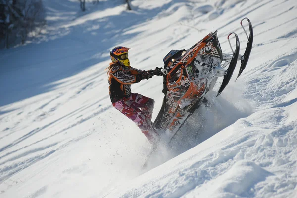 Atleta em um snowmobile que se move nas montanhas — Fotografia de Stock