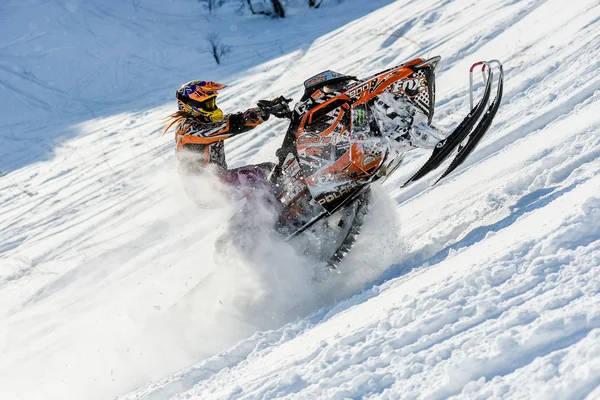 Atleta en una moto de nieve moviéndose en las montañas —  Fotos de Stock