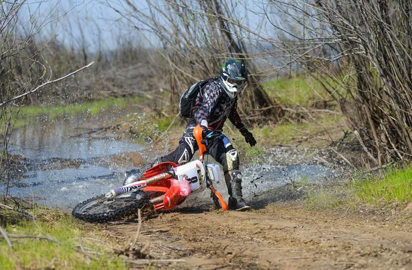 Enduro motorcycle rides through the mud with a big splash — Stockfoto