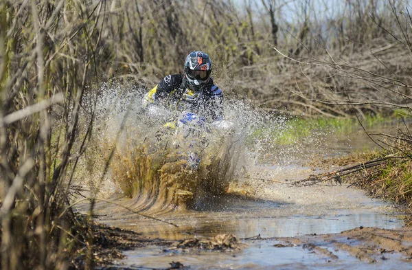 Enduro motorcycle rides through the mud with a big splash — Stockfoto