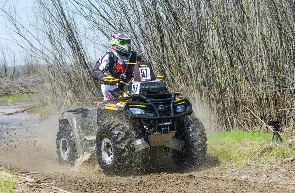 ATV rides through the mud with a big splash