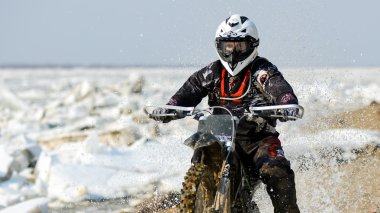 Enduro motosiklet rastasia buz Nehri üzerinde sürme vardır