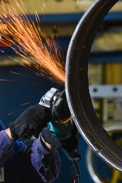 Trabajador de corte de metal con amoladora. Chispas mientras moliendo hierro —  Fotos de Stock