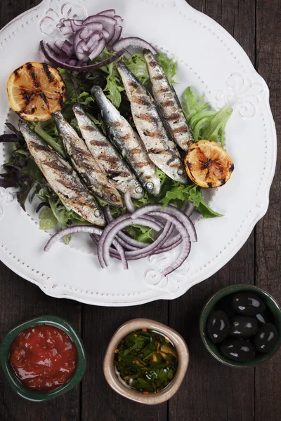 Peixe sardinha grelhado com limão e alface — Fotografia de Stock
