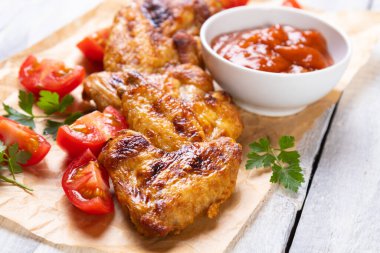 Izgara ya da kızarmış baharatlı tavuk kanadı ve bbq sosu.