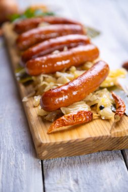 Lahana ya da lahana turşusuyla servis edilen ızgara Alman sosisi.