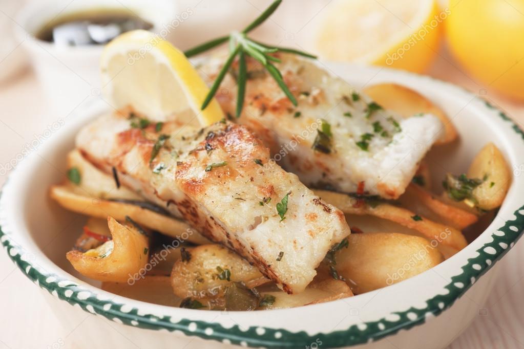 Cod fish steak with fried potato and lemon