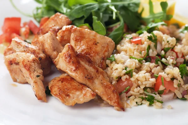 Chicken meat with bulgur and rocket salad — Stock Photo, Image