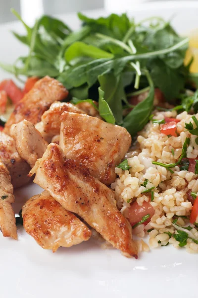 Chicken meat with bulgur and rocket salad — Stock Photo, Image