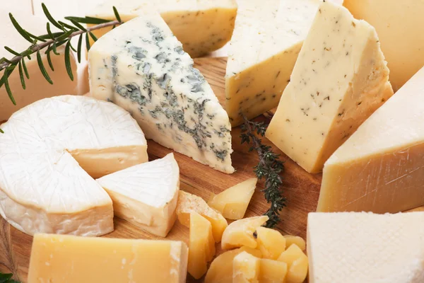 Assorted cheese on wooden platter — Stock Photo, Image