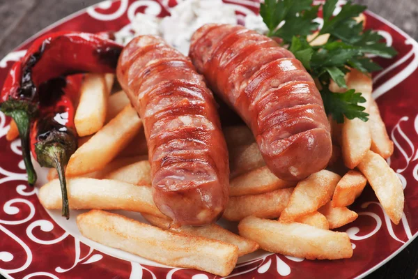 Salsichas grelhadas com batatas fritas — Fotografia de Stock