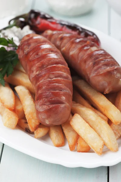 Salsiccia alla griglia con patatine fritte — Foto Stock