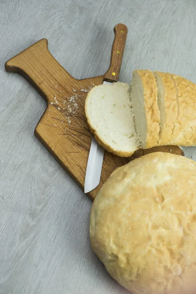 Pão com faca na tábua de corte — Fotografia de Stock