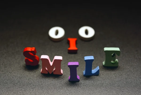 Smile разноцветный текст на черном — стоковое фото