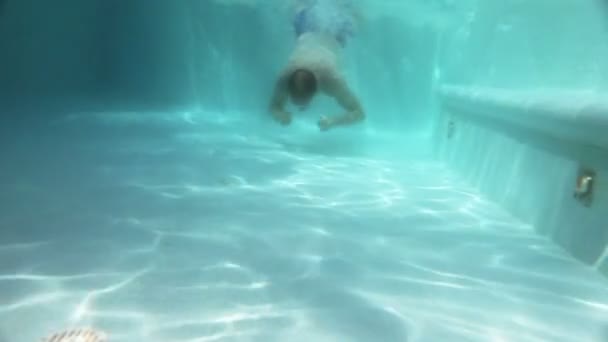 Чоловік плаває під водою в басейні — стокове відео