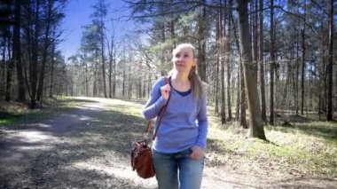 Mutlu kadın parkta bir patika erken ilkbaharda devam ediyor