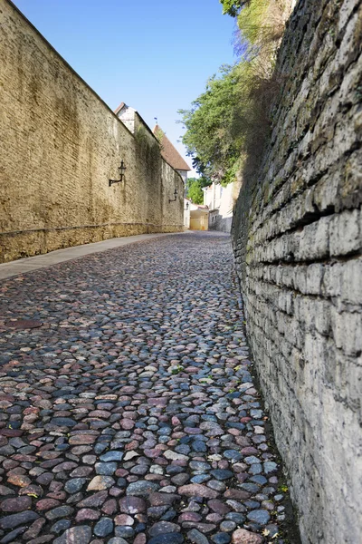 Halmozott járda és a lenyűgöző tégla falak. Régi város, Tallinn, Észtország — Stock Fotó