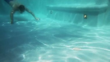 Havuzda su altında adam yüzüyor