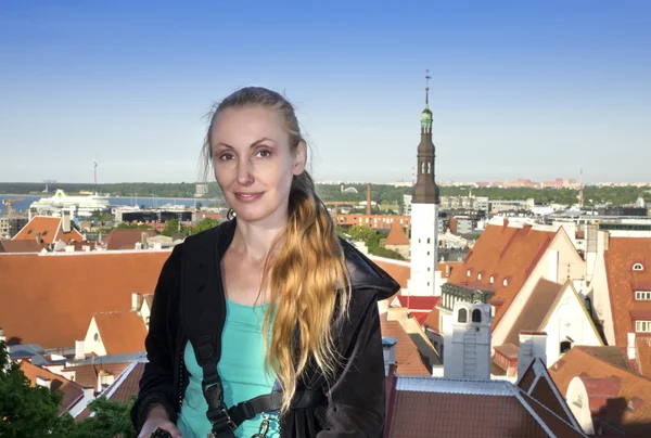 A fiatal, vonzó nő a tetők, a házak, a régi város a megfigyelő fedélzetre csodálja. Tallinn. Észtország. — Stock Fotó