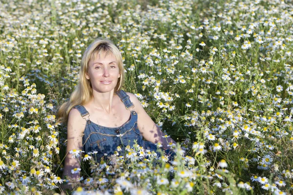 La giovane donna felice nel campo della camomilla — Foto Stock