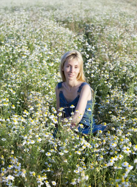 Den glada unga kvinnan inom camomile — Stockfoto