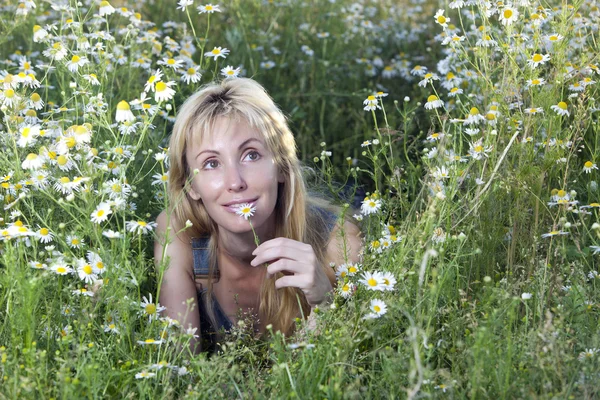 Die glückliche junge Frau auf dem Feld der Kamille — Stockfoto