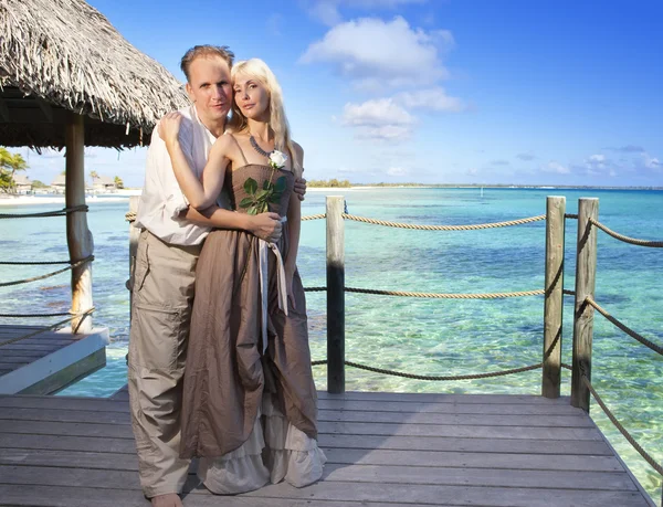 man gives a rose to the woman on the turquoise sea background