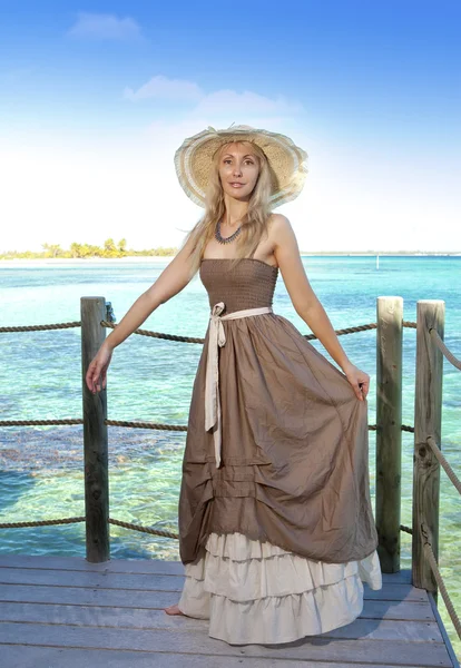Piękna kobieta w długiej sukni na platformie drewniane nad morzem — Zdjęcie stockowe