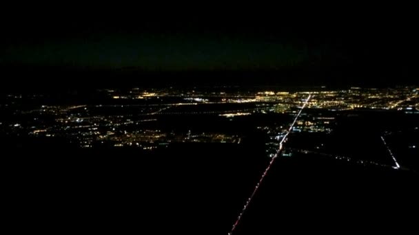 Uçak gece şehirde uçar. Yolcu penceresinden havadan görünümü. — Stok video