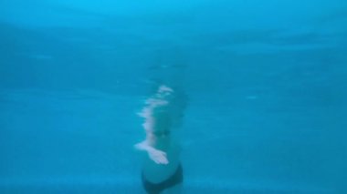 Havuzda su altında adam yüzüyor